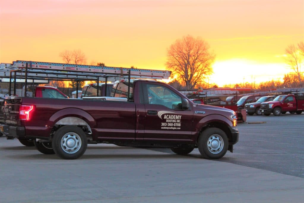 academy roofing truck in denver colorado in front of the sunset